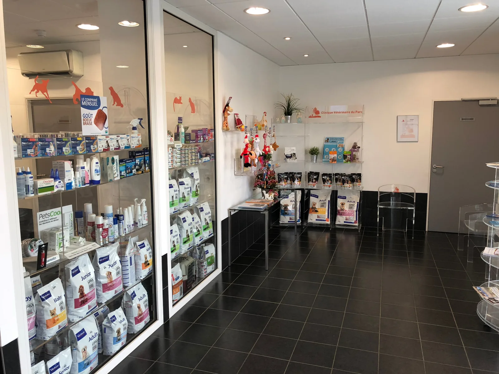 Salle d'attente et espace de vente de la clinique vétérinaire : aliments, antiparasitaires et accessoires pour chiens et chats